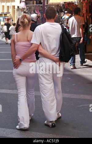 Ajaccio young couple walking arm in arm along typical town centre street Stock Photo