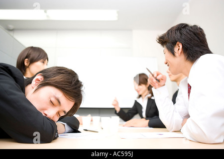 Young businessman sleeping during meeting Stock Photo