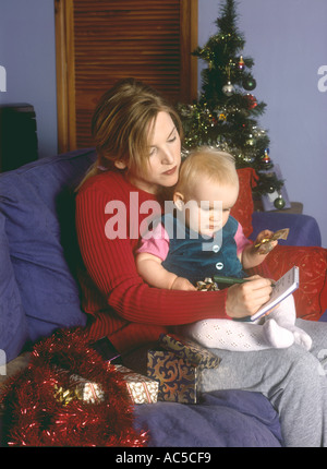 Mother with a baby writing a Christmas list or letter to Santa Claus Stock Photo