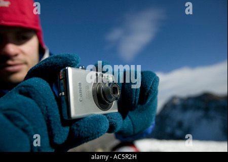 Man taking picture with compact digital camera in mountains Stock Photo
