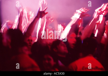 Moody niteclub scene with concertgoers waving arms Adults Only Arms Raised Red Fan Front View Human Arms Large Group Of People Stock Photo