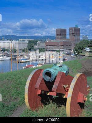 Old cannon with Oslo Rådhus ( City Hall ) beyond, seen over Oslo Harbour from Akershus Festning ( Fortress ), Oslo, Norway. Stock Photo