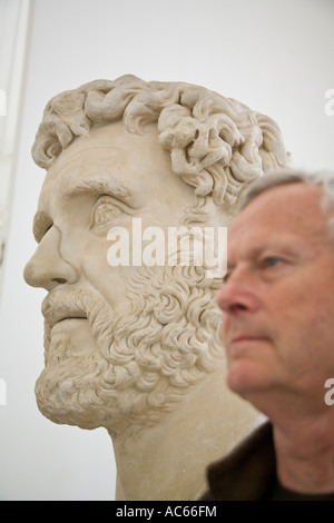 Profile view of modern man alongside marble statueTesta di Antonino Pio at the Museo Archeologico Nazionale Napoli Italy Stock Photo