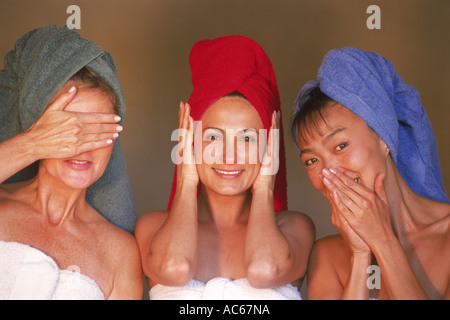 Three women of ethnic mix with colorful bath towels expressing old Asian proverb, "See no evil, hear no evil, speak no evil" Stock Photo