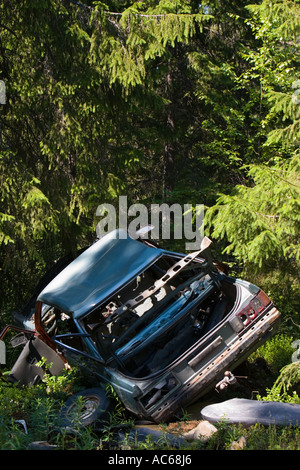 Stripped blue car wreck in the forest , Finland Stock Photo