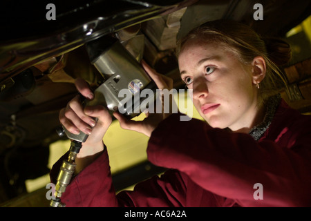 Female vehicle mechanic working on car in garage UK Stock Photo