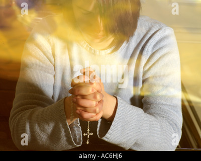 Woman Praying with a Rosary Stock Photo