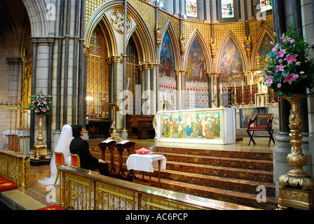 Couple at the church alter getting married. A newly married couple sitting at the alter in a church in the center of London. Stock Photo