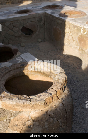 clay pot and marble counter in the Grande Taberna in herculaneum italy Stock Photo