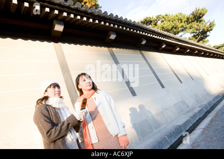Two young women using mobile phone Stock Photo