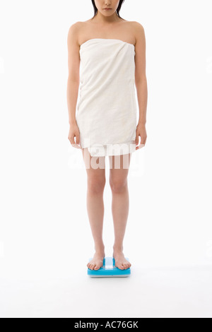 Woman standing on bathroom scale Stock Photo