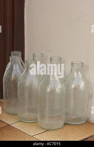 7 Seven pint Milk bottles awaiting collection on a doorstep , UK Stock Photo