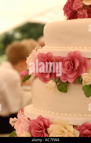 close up of a red rose decorated three tier wedding cake, wales UK Stock Photo