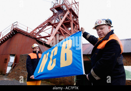 Guides, former miners,  with NCB 'National Coal Board' flag at the Big Pit National Coal Museum Blaenavon South Wales UK Stock Photo