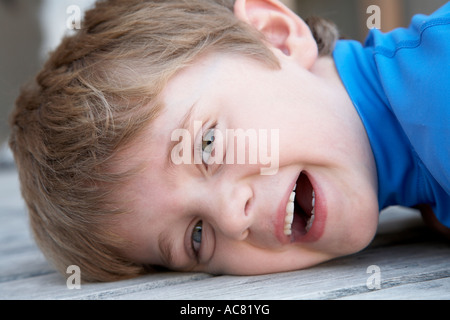 boy 7 laying on deck smiling Stock Photo