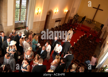 Vicar and congregation after a wedding ceremony leaving the church Stock Photo