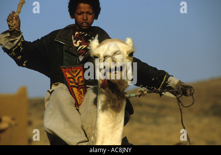 Young Tuareg boy on his camel pulling water from the well in the village of Anhar, Sahara Desert, Northern Mali, West Africa Stock Photo