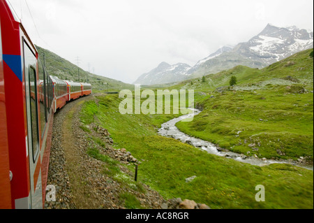 the Bernina Express train in Switzerland from Chur to Tirano in Italy approaching the summit at Bernina Pass Stock Photo