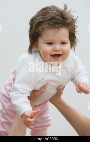 Baby girl being lifted Stock Photo