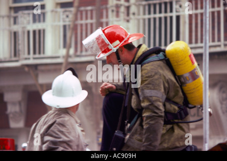 Firefighters / Firemen talking at Fire Fighting Scene Stock Photo