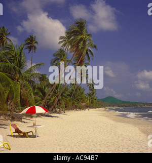 A tropical beach scene with empty deck chair red & white sun brolly on east coast beach on Koh Samui Island Thailand Stock Photo