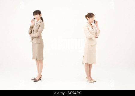 Two young businesswomen talking on mobile phones Stock Photo