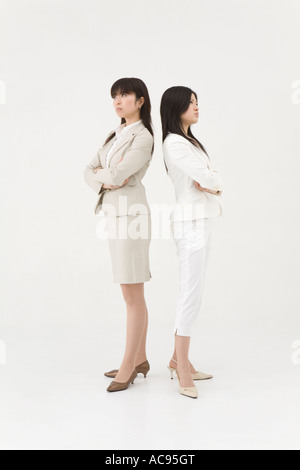Two businesswomen standing back to back Stock Photo