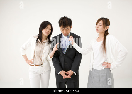 Two businesswomen fighting over man Stock Photo