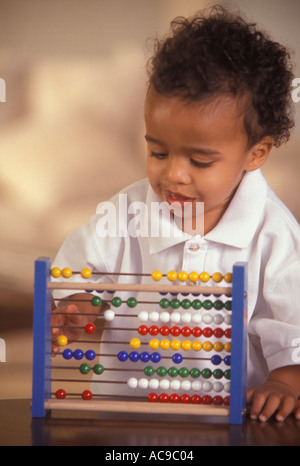 Fifteen month old little boy plays with abacus Stock Photo