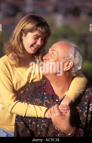 young person people Tween tweens Teenage girl standing behind her grandfather hugging and looking at each other outdoors in backyard   POV © Myrleen Pearson Stock Photo