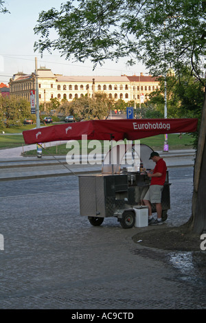 Street vendor preparing snacks under Eurohotdog umbrella, Prague. Stock Photo