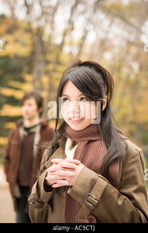 Young woman smiling boyfriend in background Stock Photo
