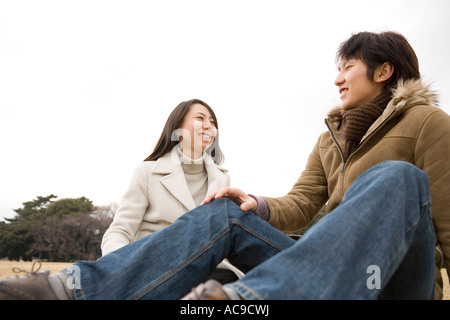 Young couple sitting on ground Stock Photo