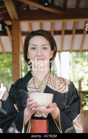 Young woman in kimono holding tea cup Stock Photo