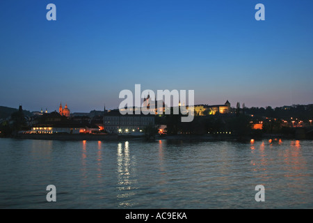 Twilight view of Prague Castle and St. Vitus Cathedral reflecting on the Vltava River in the evening. Stock Photo