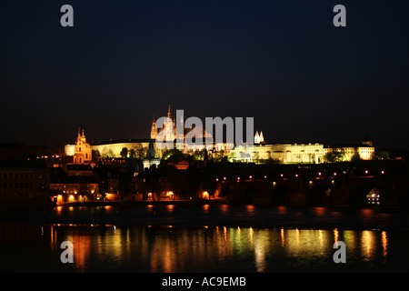 Prague Castle is seen at night, Vltava river and Charles Bridge are seen in the foreground. Stock Photo