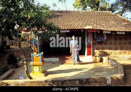 Indian female posing outside her home with tulsi vrindavan holy basil plant, Colva, Goa, India 2003 Stock Photo