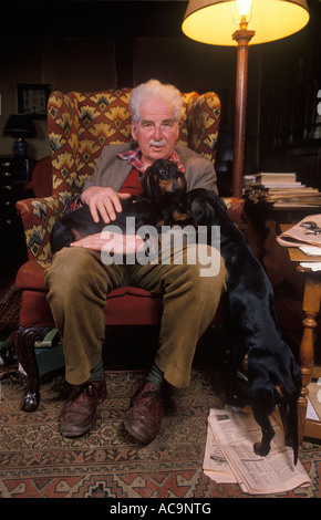 Garden designer author and plantsman Christopher Lloyd at Great Dixter, his home interior with his Dachshunds Dog East Sussex England 1990s 1995 Stock Photo