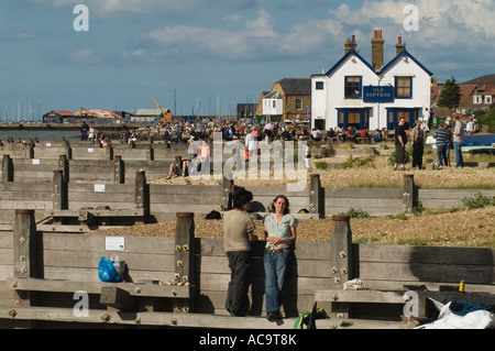 Old Neptune Public house Whitstable beach, holidaymakers leaning up against a groyne weekend away  Kent UK 2007 2000s  HOMER SYKES Stock Photo