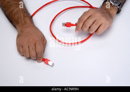 Hands of an Indian programmer showing ethernet cable Stock Photo