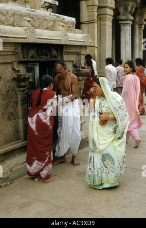 Women greeting a Hindu priest outside the famous Sri Ranganathaswamy Temple, Tiruchirappalli, Tamil Nadu, India. Stock Photo