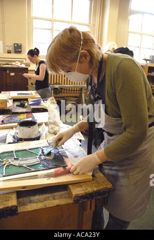 Woman working on stained Glass panel in adult learning class. Model release front person Stock Photo