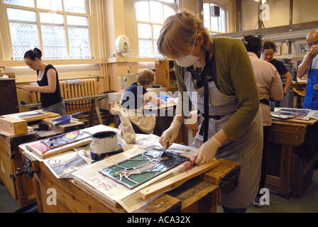 Woman working on stained Glass panel in adult learning class. Model release front person Stock Photo