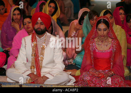 Sikh man and woman during marriage ceremony in temple or gurdwara, Hounslow, Middlesex, UK. Stock Photo