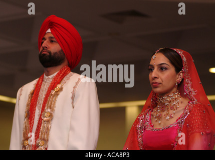 Sikh man and woman during marriage ceremony in temple or gurdwara, Hounslow, Middlesex, UK. Stock Photo