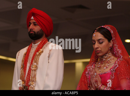 Sikh man and woman during marriage ceremony in temple or gurdwara, Hounslow, Middlesex, UK. Stock Photo