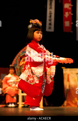 Young Japanese Girl Fan Dancer from Ikuta Shinto Shrine in Japan wearing Kimono, dancing Traditional Dance Performance on Stage Stock Photo