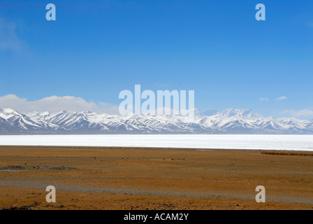 Wide view across ice covered Nam Tso Lake towards Nyengchen Tanglha mountains Tibet China Stock Photo