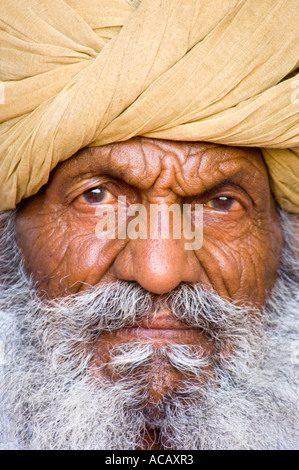 Close up portrait of a wrinkled old Indian man with a grey beard and turban on his head at the Mehrangarh Fort in Jodhpur. Stock Photo