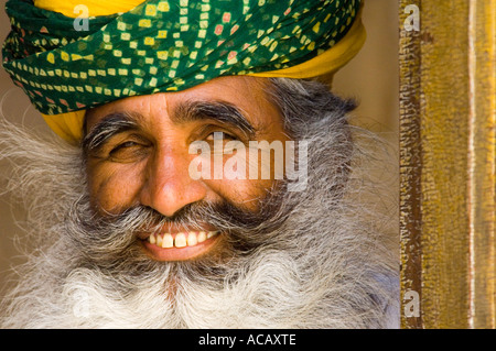 Portrait of a smiling turbaned elderly Indian man with a grey bushy beard at the Mehrangarh Fort. Stock Photo